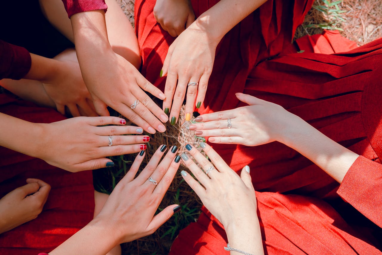 services-02 A vibrant top view of women showcasing painted nails and rings, emphasizing friendship and togetherness.